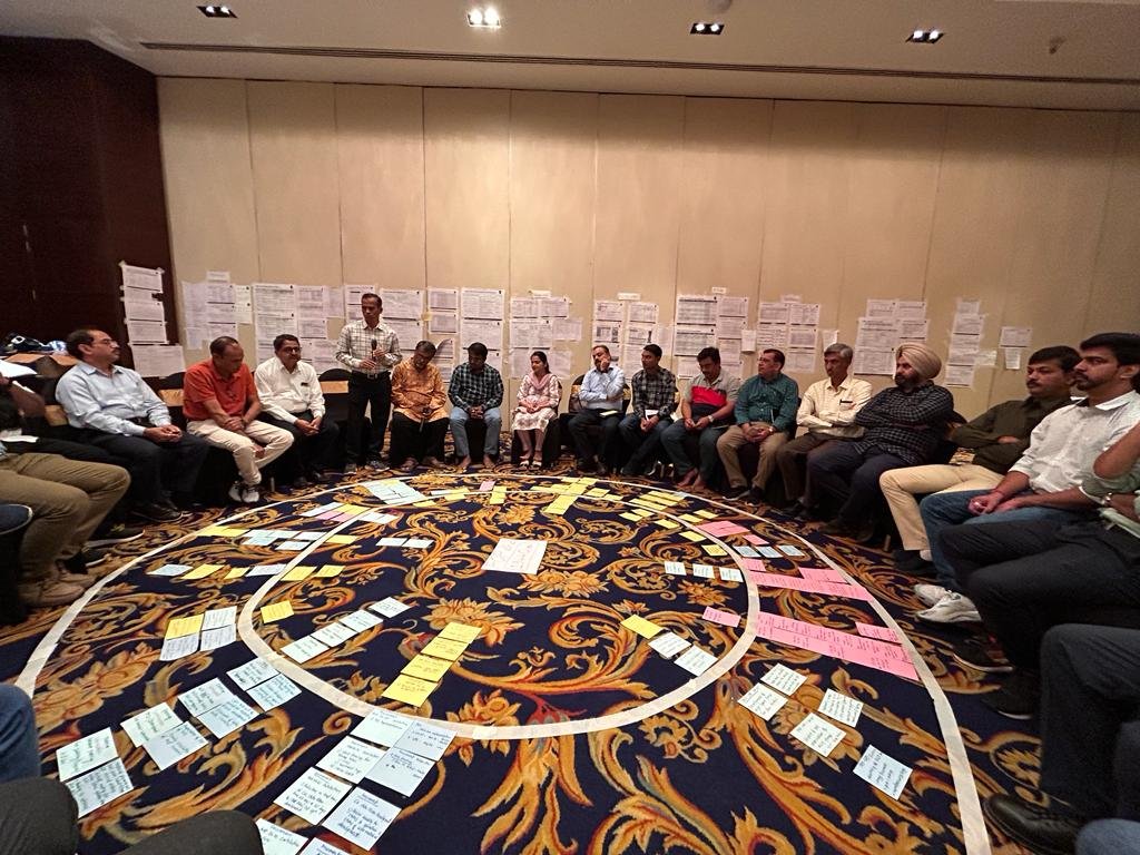 Department heads seated in a circle reviewing cross-functional dependencies
