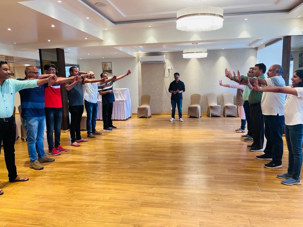 Team members holding hands in a circle during a trust-building exercise