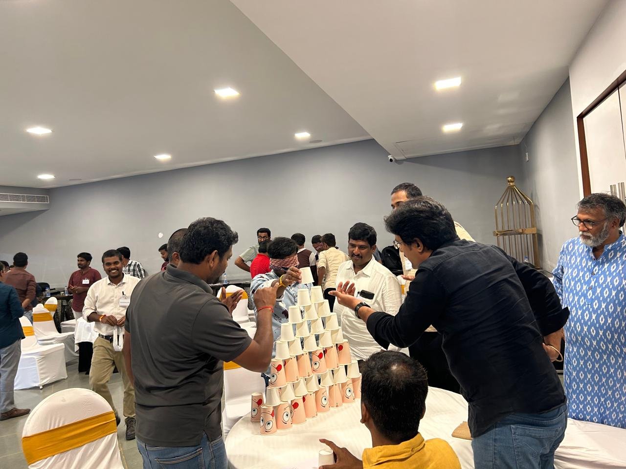 Team members collaborating on a cup-stacking challenge